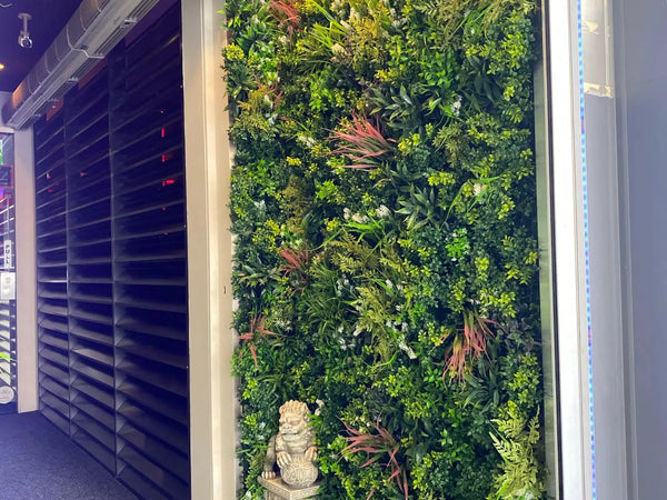 Lush artificial vertical garden beside a dark entrance doorway