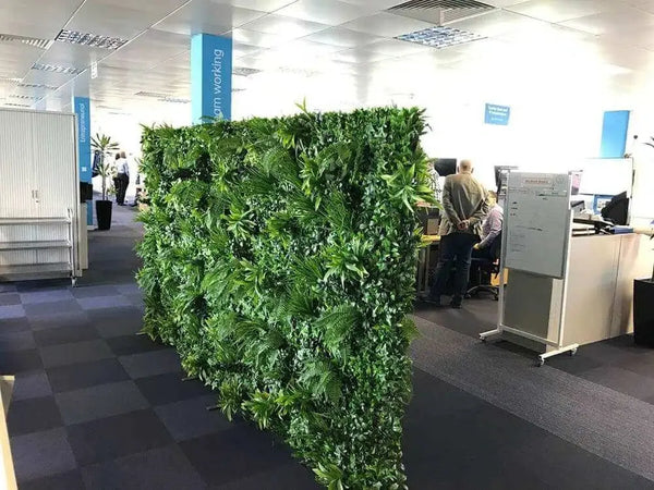 Freestanding artificial green wall partition between desks in an open-plan office
