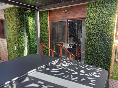 Natural artificial boxwood hedge panel installed onto a deck