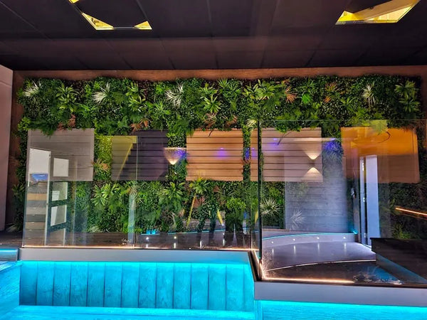 Artificial green wall behind a reception counter lit with blue lighting