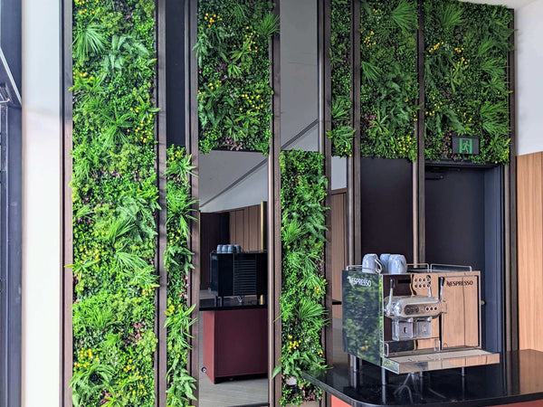 Artificial green wall columns behind a coffee counter in a hotel