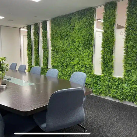 Boardroom with vertical artificial green wall strips between white wall panels.