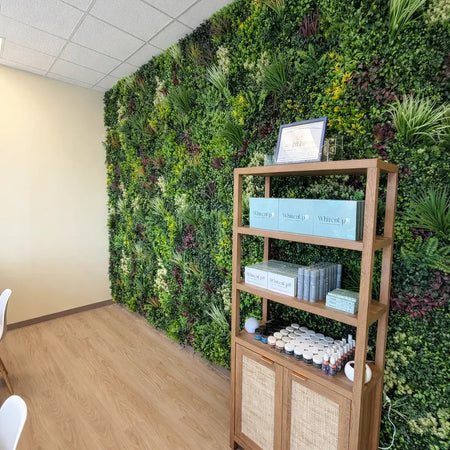 Artificial green wall behind a wooden bookshelf in a home office.