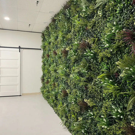 Artificial green wall covering a showroom wall beside white barn doors.